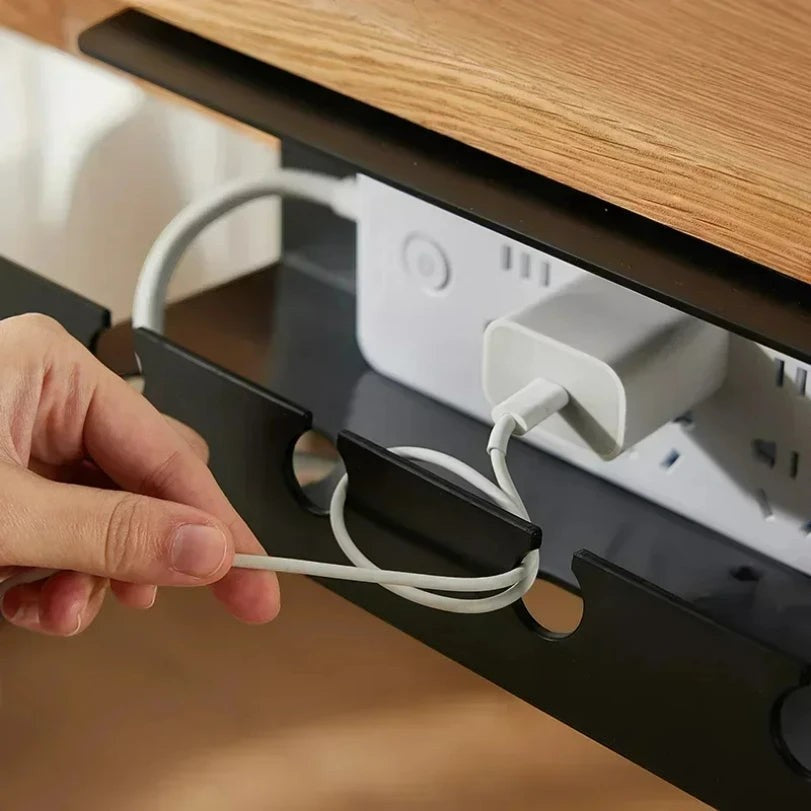 Doctor Desk black metal under desk cable tray with clamp mount holding a power strip and cables on a wooden desk