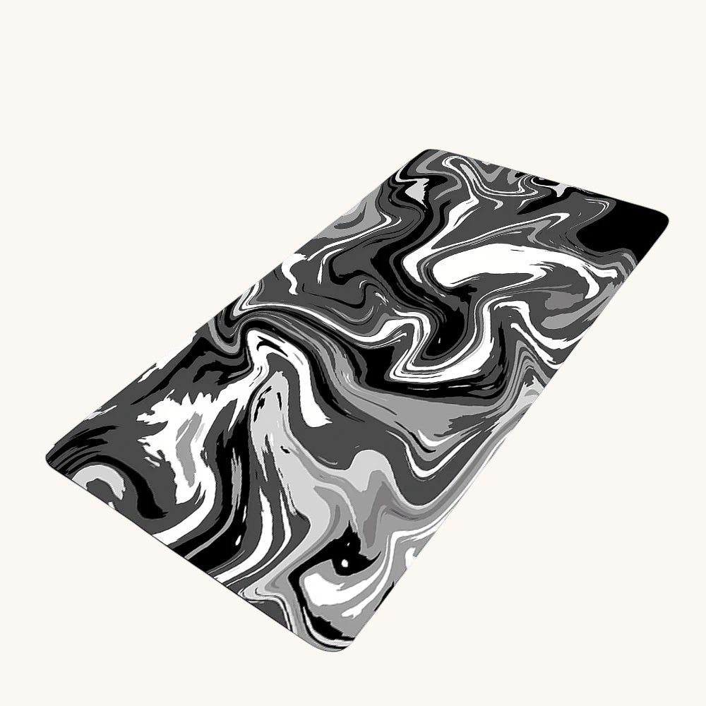 Doctor Desk XXL desk mat with black and white liquid swirl pattern, featuring a non-slip rubber base and stitched edges